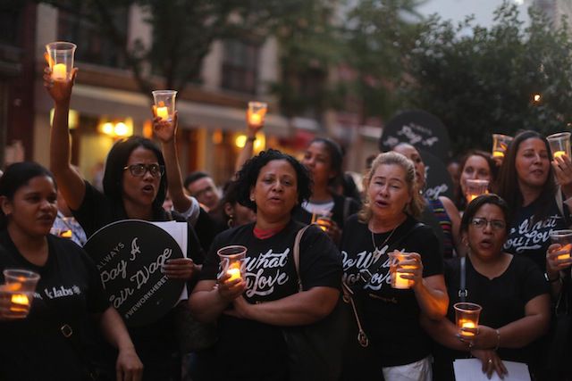 Former WeWork cleaners held a vigil for their lost jobs in front of WeWork headquarters on Monday night.